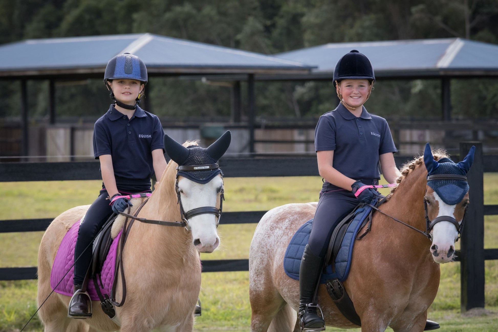 two young riders on show ponies smiling with steadyhands riding gloves